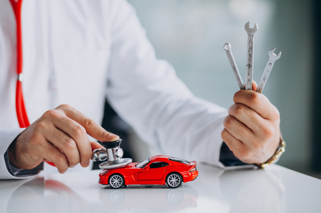 Car technician checking a car with a stethoscope